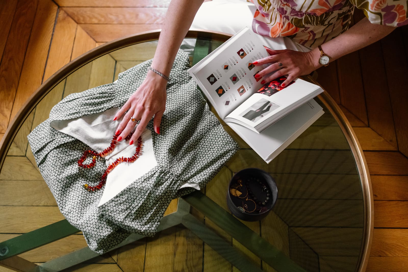 Vue du dessus d'une robe, d'un collier et d'un nuancier posés sur une table basse en verre