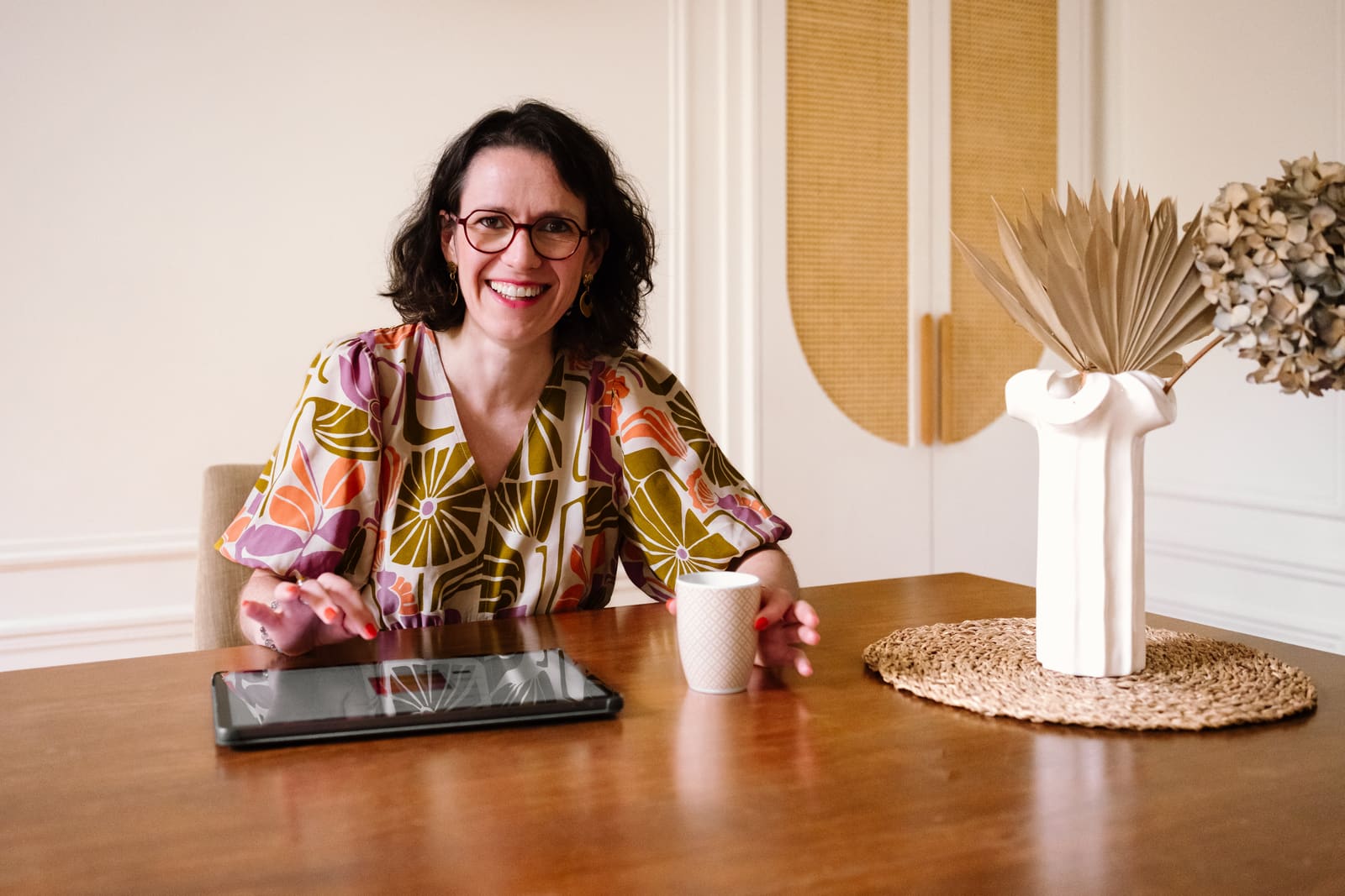 Florence, conseillère en image, souriante à sa table de travail avec une tablette
